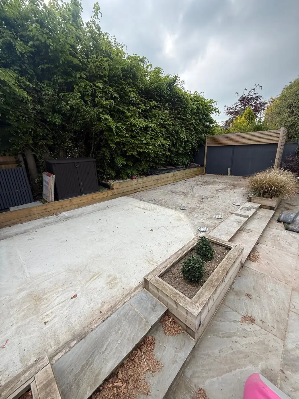 Prepared residential garden site showing installed circular foundation heads before the steel frame